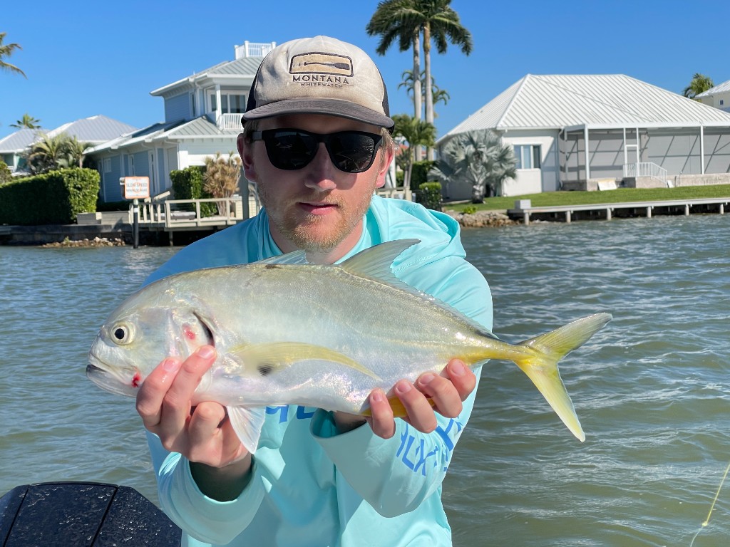 Angler with a jack crevalle in a coastal canal