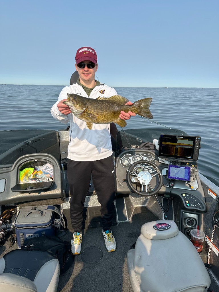 Angler with a smallmouth bass on a fishing boat